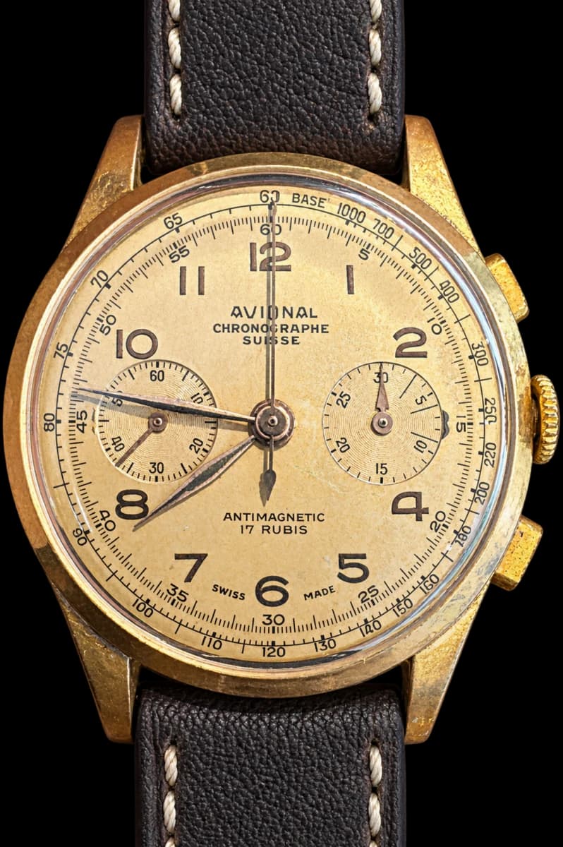 Two-register chronograph with an aged champagne dial and black strap with pale stitching