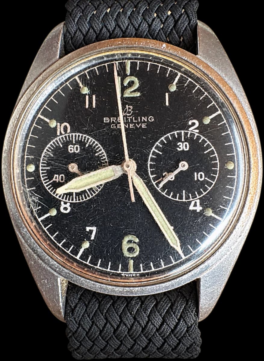Chronographe à deux compteurs, cadran noir, verre marqué par l’usage et bracelet noir tressé